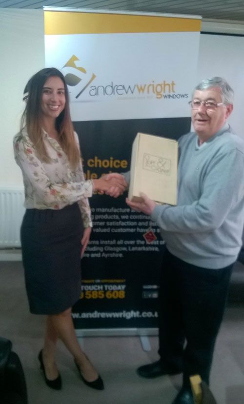 Veka Group's Amy Grundy presents Charlie Berry of Andrew Wright Windows with a gift to celebrate 80 years of trading.